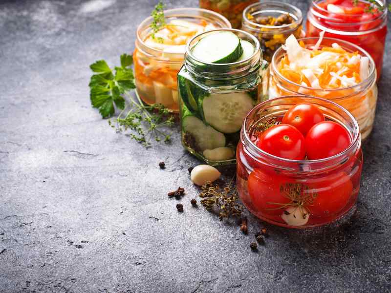 Several jars of fermented foods are on a counter