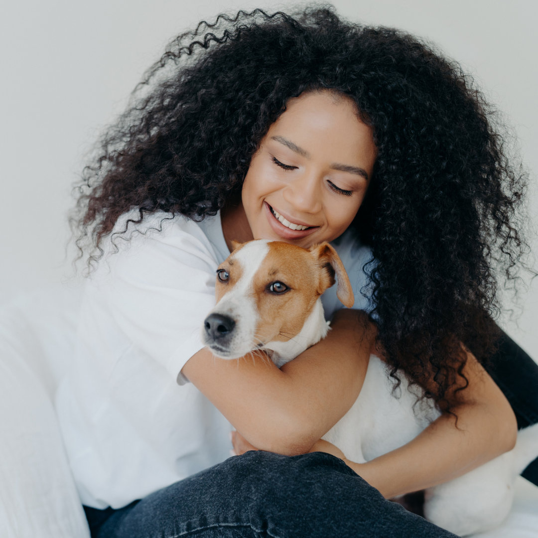 Photo of an African American woman hugging her dog.